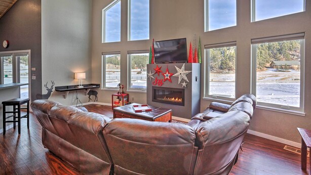 A living room with a leather sofa, a fireplace, and large windows. - 'hakuna Matata Cabin' - 11 Mi to Mt Rushmore! (Rapid City)