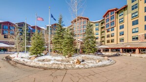 A hotel with multiple floors, a central courtyard with trees, and flags. - Ski-in/ski-out Park City Condo: Fireplace & View! (Park City)