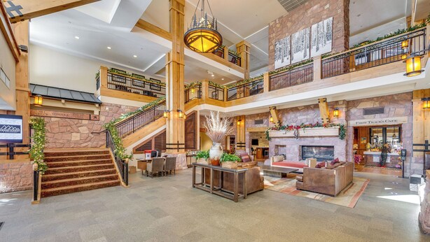 A spacious lobby with a grand staircase, a fireplace, and a coffee shop. - Ski-in/ski-out Park City Condo: Fireplace & View! (Park City)