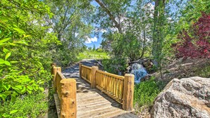 A wooden bridge leading to a waterfall surrounded by lush greenery. - Cozy Eden Condo Retreat < 6 Mi to Ski Resort! (Eden)