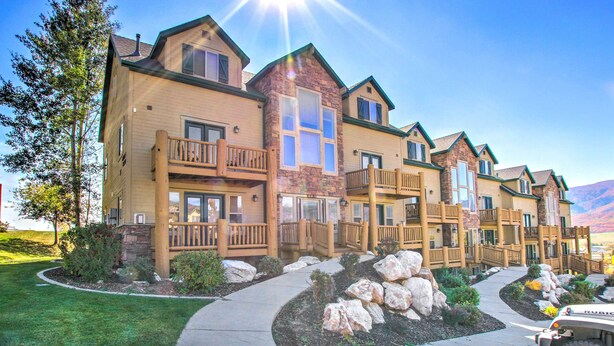 A row of multi-story buildings with balconies, a stone facade, and a clear sky. - Cozy Eden Condo Retreat < 6 Mi to Ski Resort! (Eden)