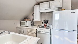 A compact kitchen with white cabinets, a microwave, a stove, and a refrigerator. - Brunswick Retreat < 1 Mi to Potomac River! (Brunswick)