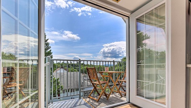 A balcony with a view of the sky and trees, wooden chairs, and a metal railing. - Brunswick Retreat < 1 Mi to Potomac River! (Brunswick)