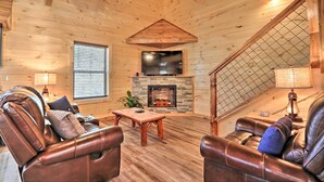 A cozy cabin interior with leather recliners, a stone fireplace, and a wooden ceiling. - Pigeon Forge Cabin w/ Hot Tub: 1 Mi to Parkway (Pigeon Forge)