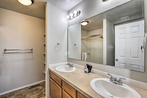 A bathroom with two sinks, a large mirror, and a towel rack. - Spacious Family Home w/ Large Deck & Fire Pit! (Caldwell)