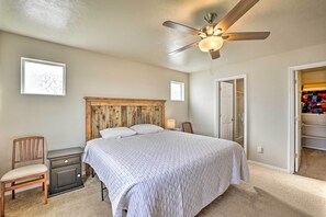 A bedroom with a bed, nightstand, chair, and a ceiling fan. - Spacious Family Home w/ Large Deck & Fire Pit! (Caldwell)
