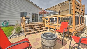 Eine Terrassenanlage mit Sitzgelegenheiten im Freien, einem Feuerkorb und einem überdachten Sitzbereich.