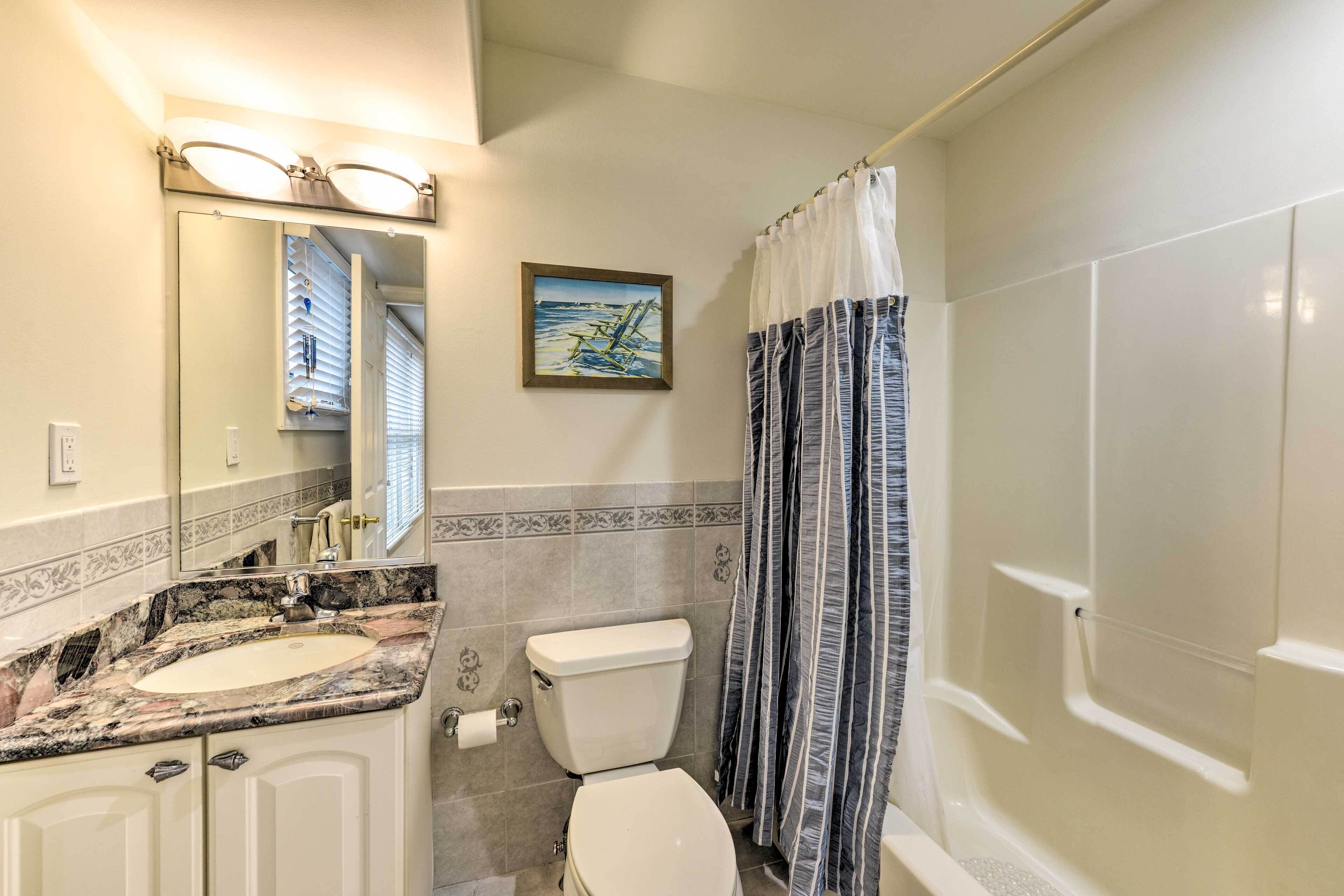 Une salle de bain avec un lavabo, des toilettes et une douche.
