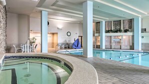 An indoor swimming pool with a separate hot tub area, lounge chairs, and a clock on the wall. - Resort Living on Lake of the Ozarks! Family Cabin (Osage Beach)