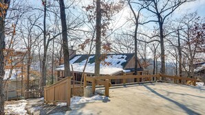 A wooden deck with a concrete pathway leading to a building with a green roof. - Resort Living on Lake of the Ozarks! Family Cabin (Osage Beach)