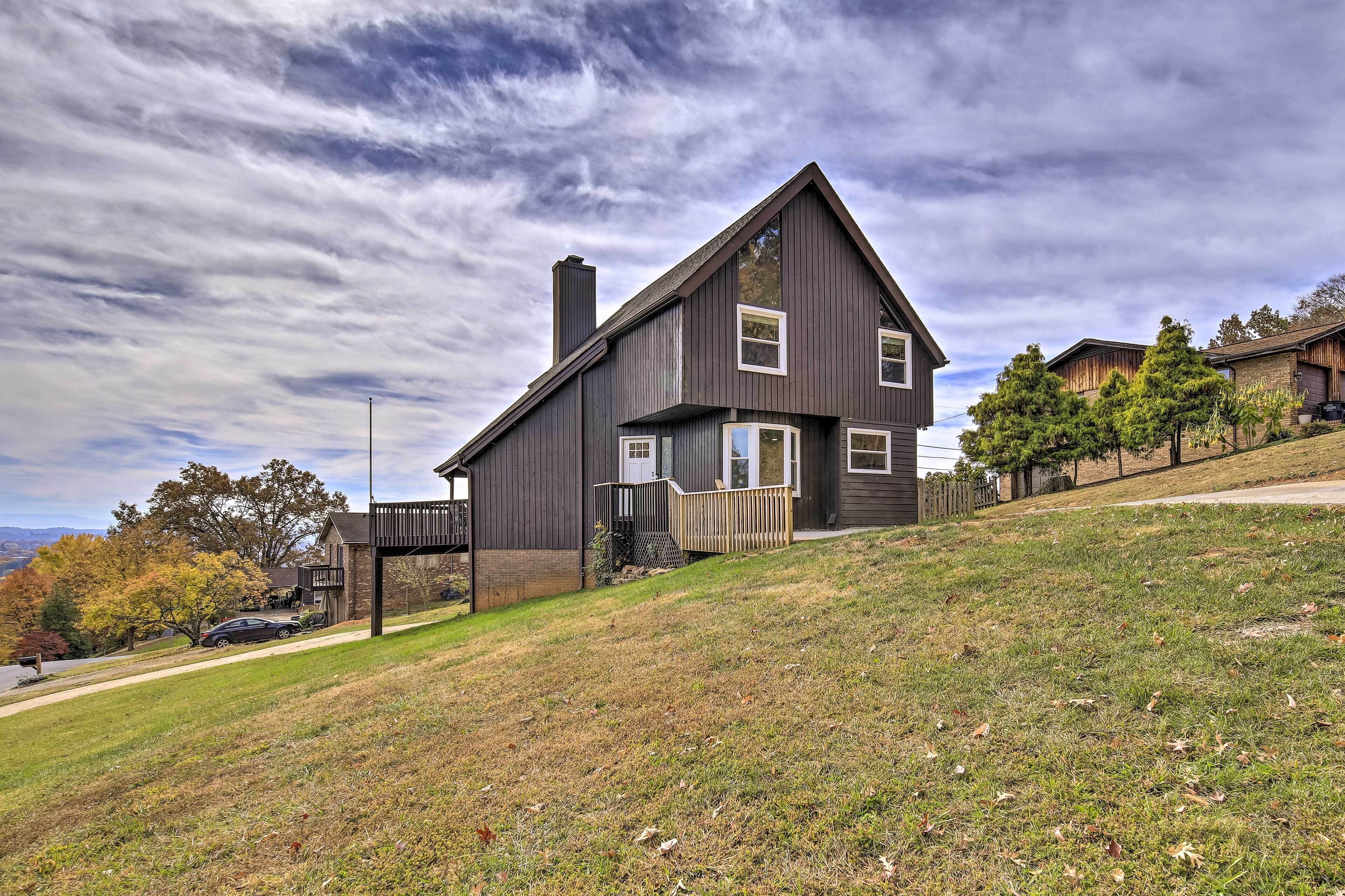 A modern two-story house with a steep roof, a covered porch, and a fenced yard.