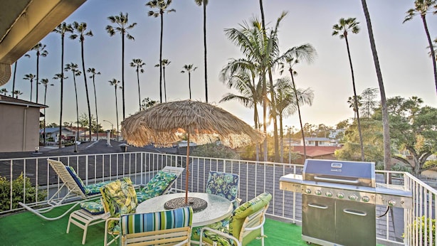 An outdoor patio with a round table, chairs, a grill, and a thatched umbrella. - Quaint La Mesa Home With Beautiful Sunsets! (La Mesa)