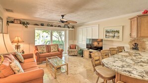 A spacious living room with a large TV, comfortable seating, and a dining area with a marble table. - Marathon Vacation Rental With Pool Access! (Marathon)