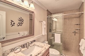 A bathroom with a marble sink, a large mirror, a glass shower enclosure, and a toilet. - Marathon Vacation Rental With Pool Access! (Marathon)