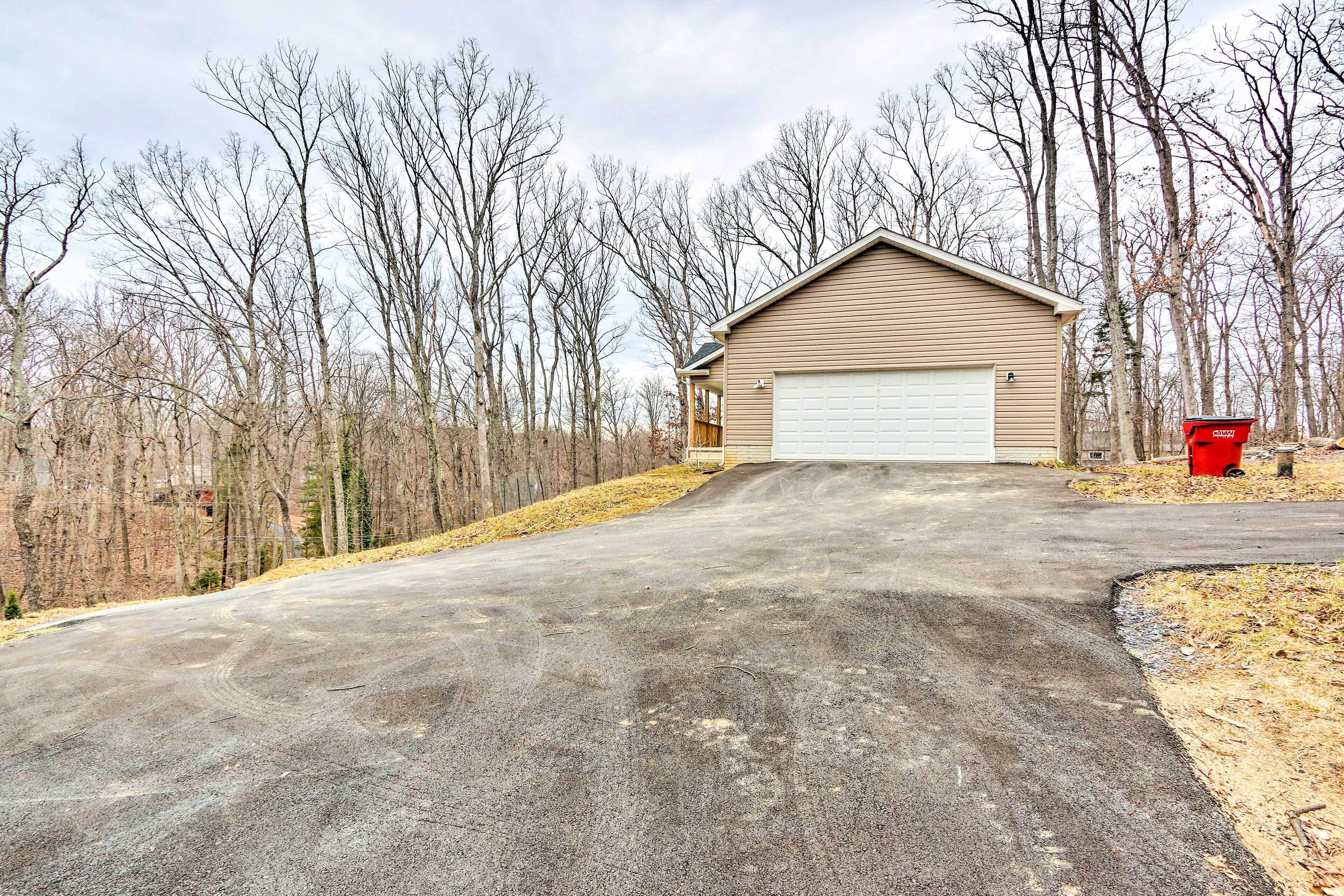 A residential driveway leading to a garage with a detached house.