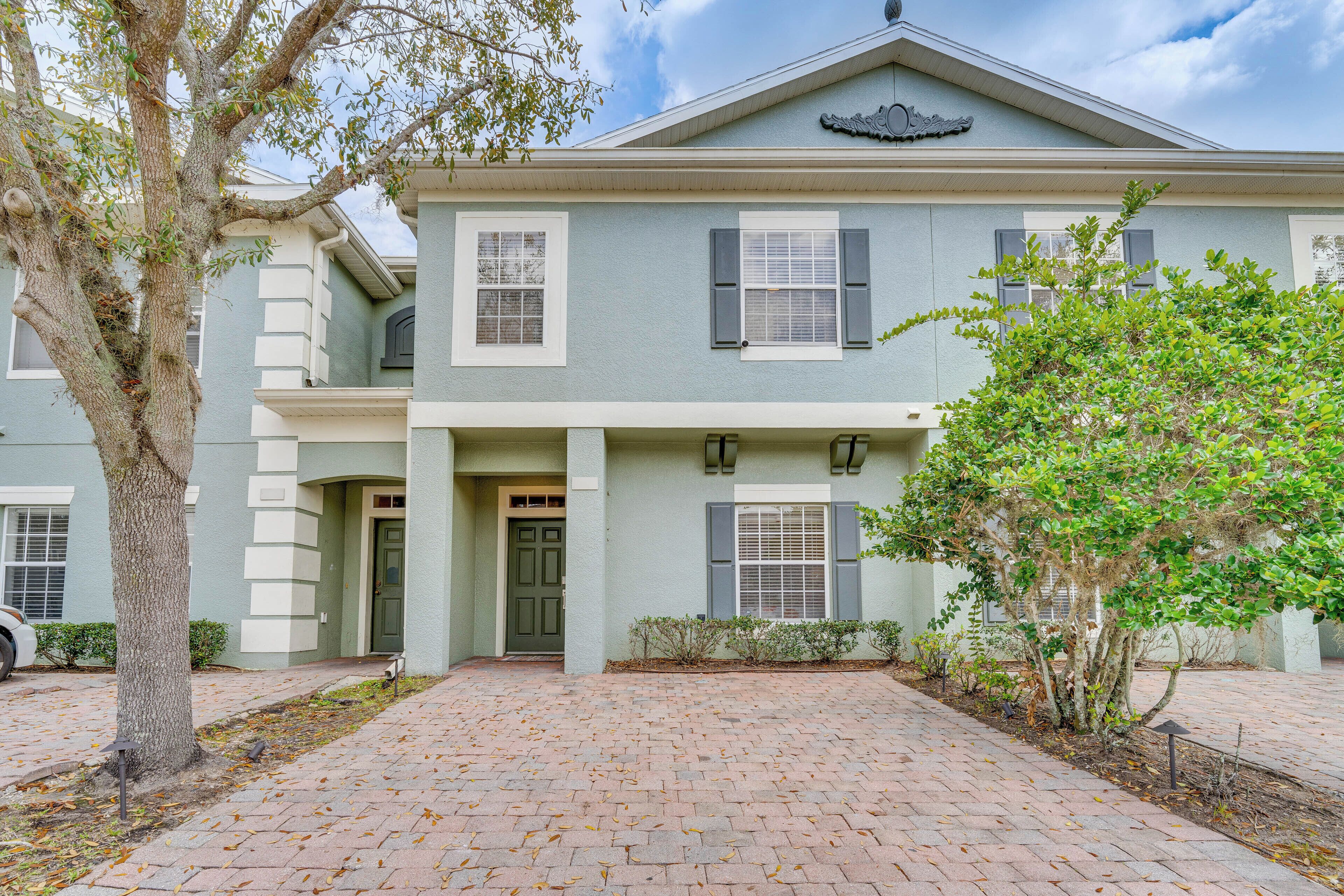 A two-story house with a front porch, a garage, and a driveway.