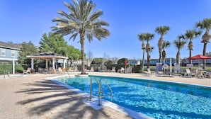A swimming pool with a palm tree and lounge chairs. - 6 Mi to Disney: Resort Home w/ Pool Access! (Kissimmee)