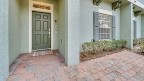 A house with a green door, a brick pathway, and a small garden area. - 6 Mi to Disney: Resort Home w/ Pool Access! (Kissimmee)
