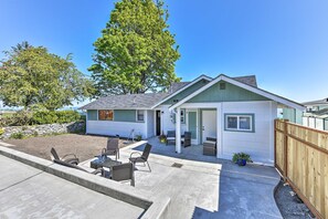 A single-story house with a patio, outdoor seating, and a fenced yard.