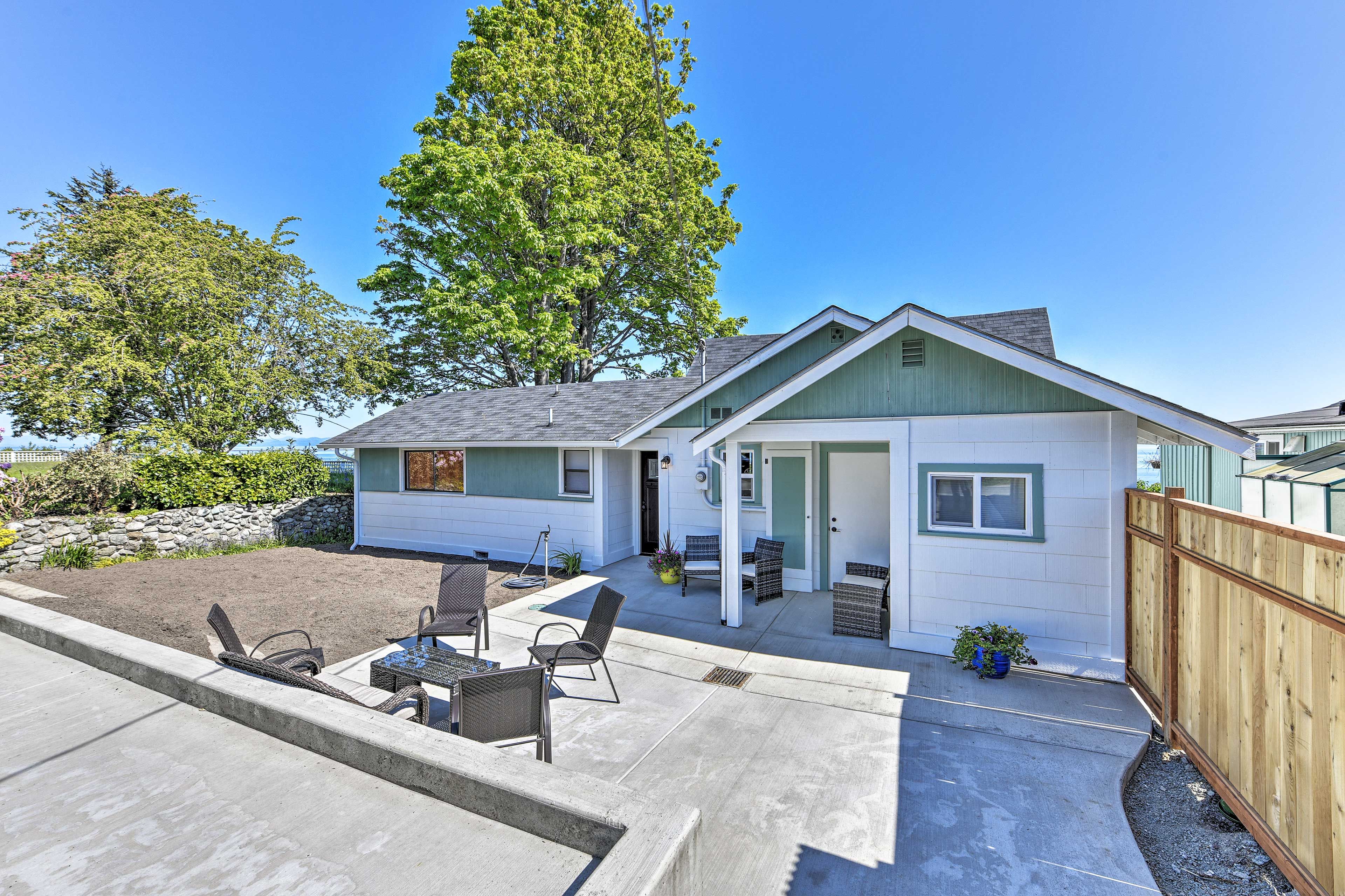 A single-story house with a patio, outdoor seating, and a fenced yard.