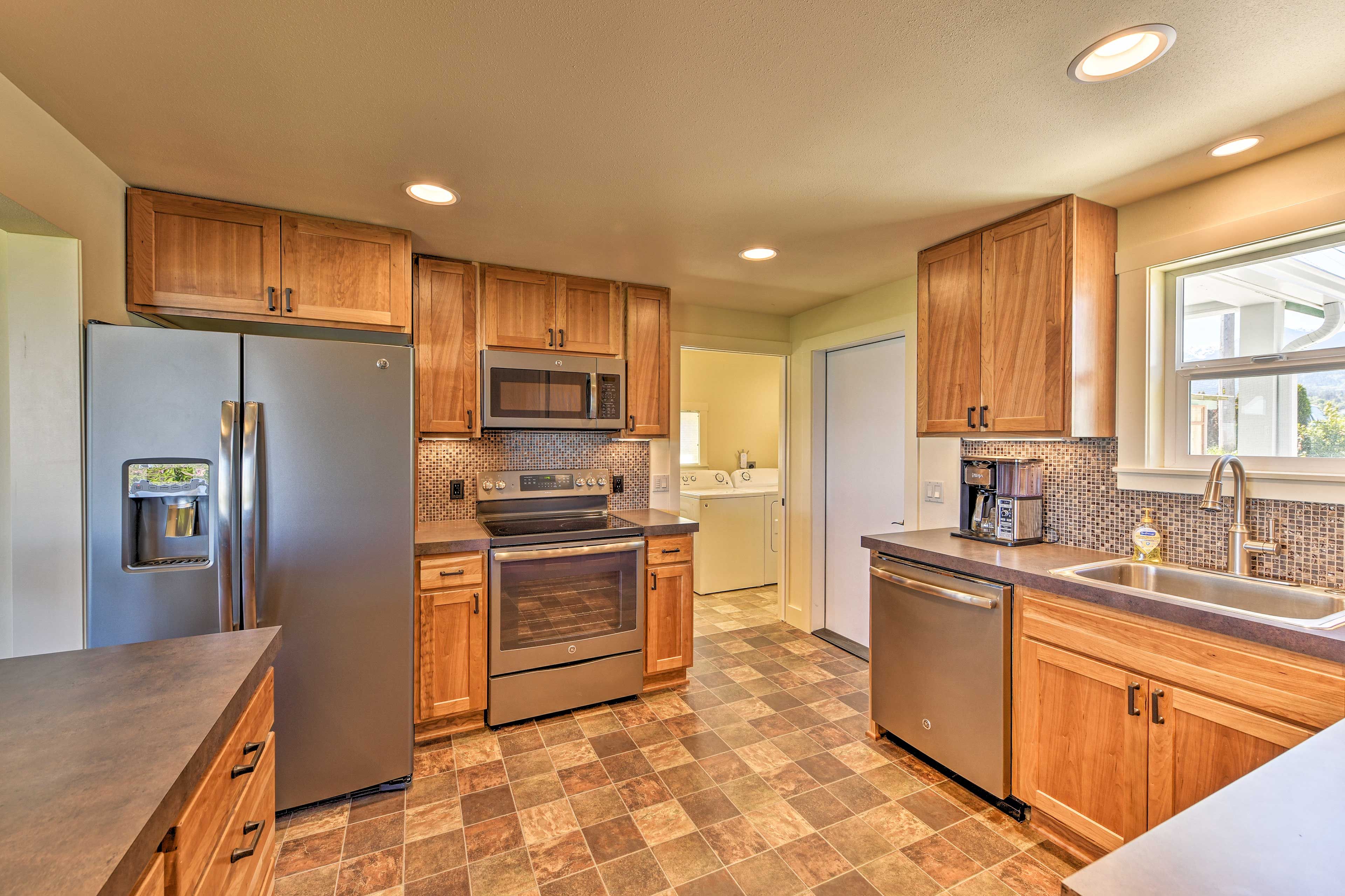 A modern kitchen with wooden cabinets, stainless steel appliances, and a tiled backsplash.