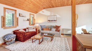 A cozy living room with a wooden ceiling, two sofas, a coffee table, and a white rug. - Serene Jonesport Escape: Deck w/ Water Views! (Jonesport)
