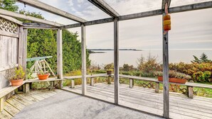 A wooden deck with a view of the water, potted plants, and a swing set. - Serene Jonesport Escape: Deck w/ Water Views! (Jonesport)