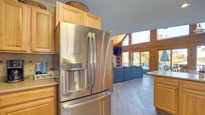 Una cucina moderna con mobili in legno, un frigorifero in acciaio inossidabile e una macchina per il caffè.