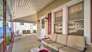 A covered porch with a sofa, chairs, and a table. - Family-friendly Wildwood Apt: Bike to Beach! (Wildwood)