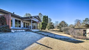 A house with a covered porch, a flag, and a gravel driveway. - Lake Balboa Access: Home w/ Dock & Yard (Hot Springs Village)