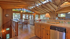 A wooden interior with a kitchen area, dining table, chairs, and a staircase. - Hillside Home w/ Deck & Views of Tomales Bay! (Inverness)