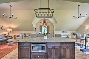 A spacious living area with a large island featuring a built-in microwave, dark wooden cabinets, and a marble countertop. - Cozy Campton Cottage < 1 Mi to Owls Nest Resort! (Campton)