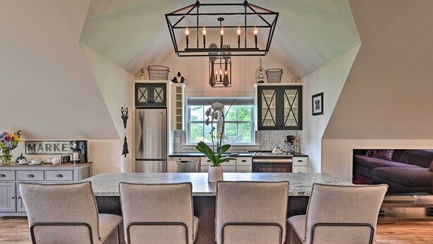 A modern kitchen with a central island, bar stools, and a chandelier. - Cozy Campton Cottage < 1 Mi to Owls Nest Resort! (Campton)
