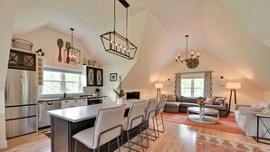 A modern kitchen with a central island, a dining area with chairs, a living room with a sofa, and a chandelier. - Cozy Campton Cottage < 1 Mi to Owls Nest Resort! (Campton)
