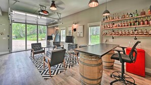 A modern kitchen with a large island, bar stools, and a wine rack. - Cozy Campton Cottage < 1 Mi to Owls Nest Resort! (Campton)