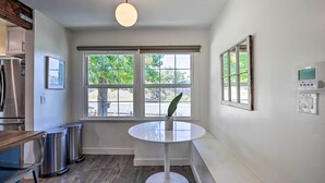 A kitchen with a white table, stainless steel trash bins, a refrigerator, and a window with blinds. - San Diego Gem w/ Private Hot Tub, Close to Dtwn! (San Diego)
