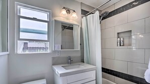 A bathroom with a toilet, sink, mirror, and shower. - San Diego Gem w/ Private Hot Tub, Close to Dtwn! (San Diego)