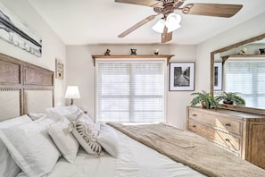 A bedroom with a bed, a ceiling fan, a dresser, and a window with blinds. - Mountain Getaway Home in a Resort Community! (Newland)