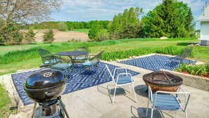 An outdoor patio with a grill, chairs, and a patterned rug. - 3 Mi to Lake Michigan: The Country Cottage (Central Lake)
