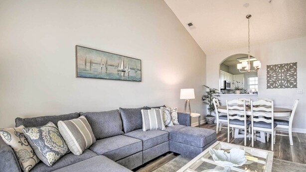 A living room with a gray sectional sofa, a glass coffee table, and a painting of sailboats. - Shuttle to Ocean! North Myrtle Beach Retreat (North Myrtle Beach)
