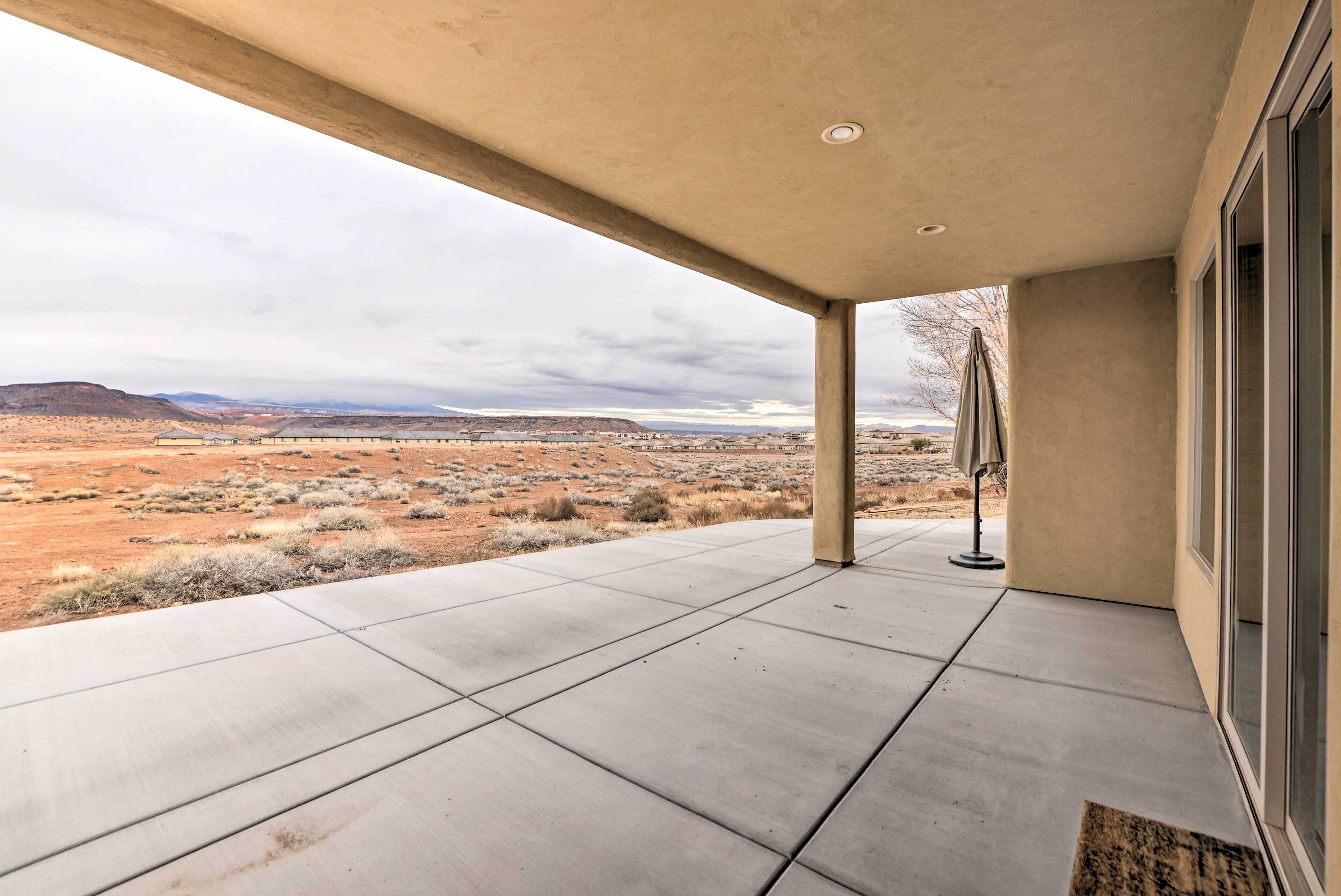 A covered outdoor area with a view of a desert landscape.
