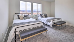 A bedroom with two beds, a ceiling fan, and large windows offering a desert view. - Modern Apartment w/ Beautiful Mountain Views! (St. George)