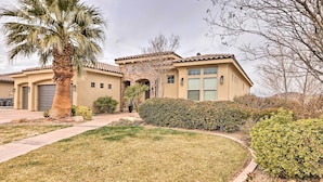 A two-story house with a beige exterior, a large front yard, and a palm tree. - Modern Apartment w/ Beautiful Mountain Views! (St. George)