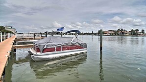 A boat docked at a pier with a wooden walkway leading to it.