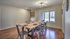 A dining area with a wooden table set for six, surrounded by metal chairs. - Spacious Bella Vista Home ~ 5 Mi to Lake! (Bella Vista)