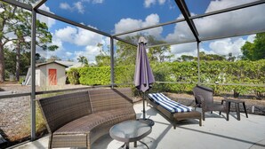 An outdoor patio with wicker furniture, a glass table, and a view of the surrounding landscape. - 2 Mi to Bonita Beach: Bbq-ready Townhome! (Bonita Springs)