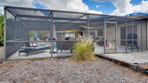 A modern glass-enclosed outdoor space with a pool, lounge chairs, and a patio area. - 2 Mi to Bonita Beach: Bbq-ready Townhome! (Bonita Springs)