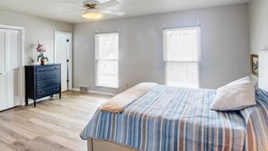A bedroom with a bed, dresser, and windows. - Pleasant Condo - 14 Mi to Dtwn Kansas City (Overland Park)