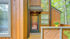 A wooden cabin with a front door, a small porch, and a window. - Near Skiing & Lakes: Contemporary Poconos Townhome (Lake Harmony)