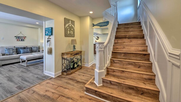 A staircase with wooden steps and white railings, leading to a second floor. - Seaside Wildwood Haven: Walk to Boardwalk/beach! (Wildwood Crest)
